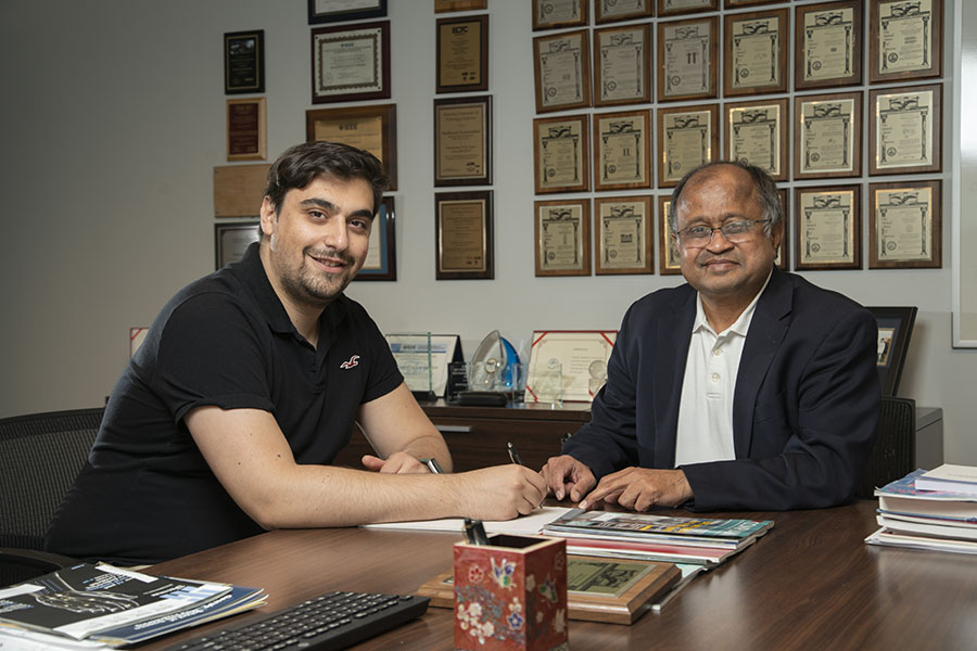 Professor Swaminathan seated with a computer